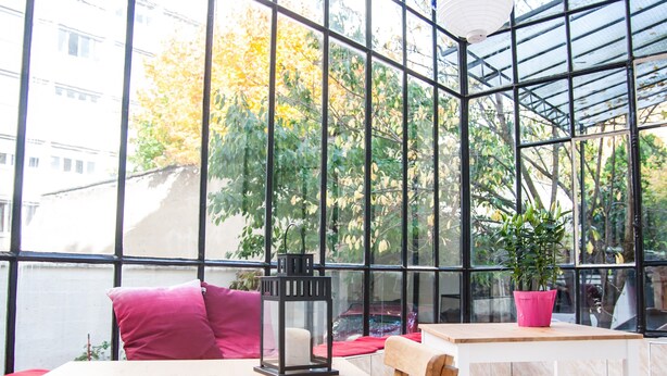 A modern interior with a glass ceiling, a wooden table, and a chair. - Félix dOrt (Lyon)