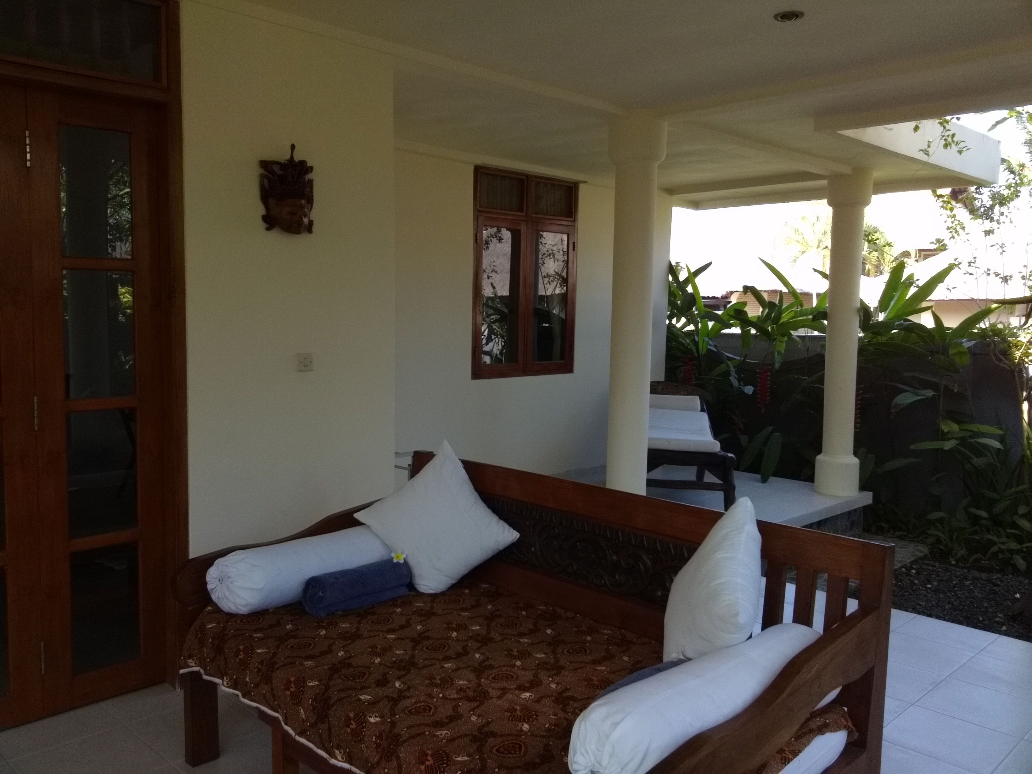 A bedroom with a bed, pillows, and a window.
