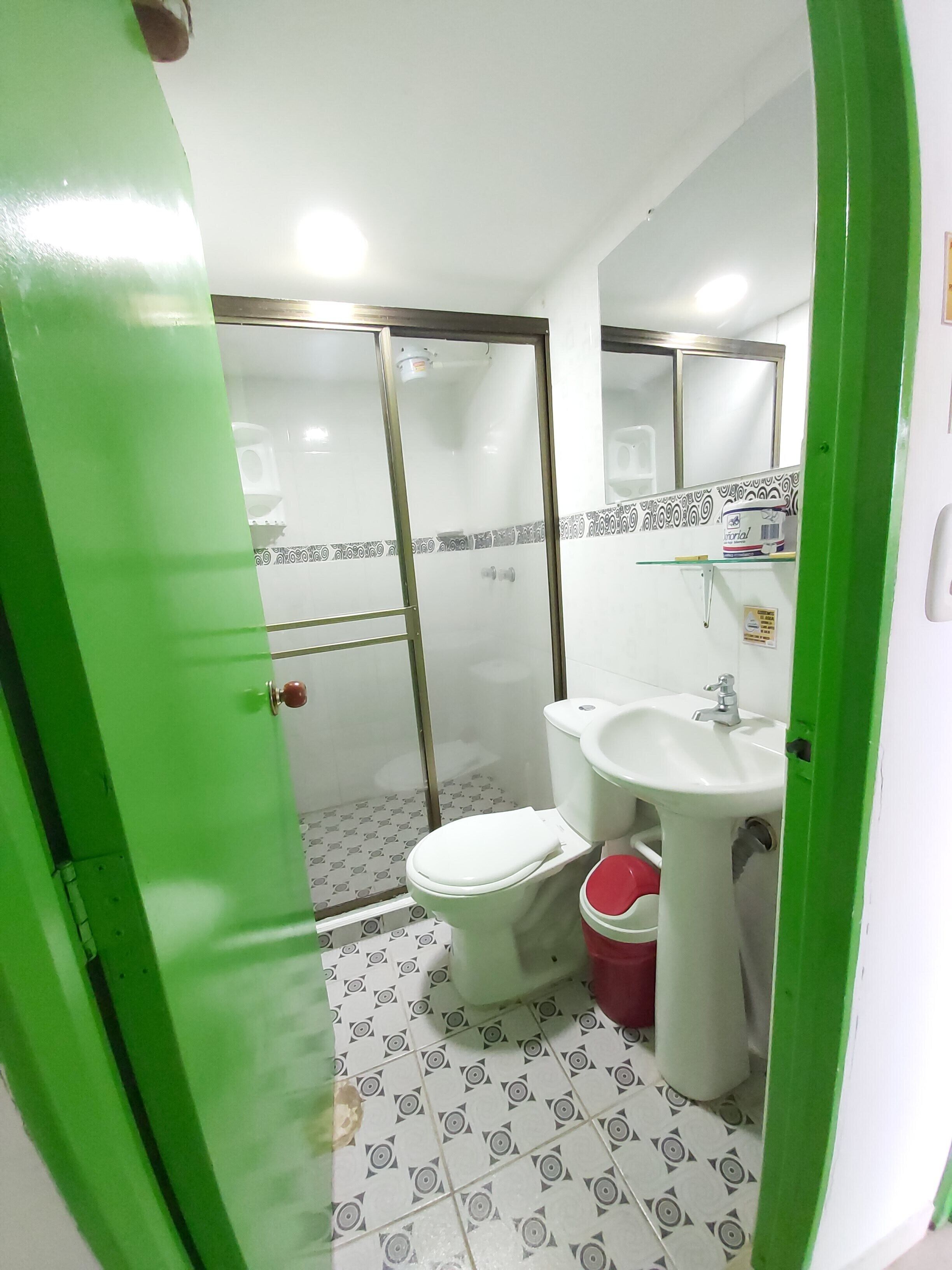 Ein Badezimmer mit Toilette, Waschbecken und Duschbereich.