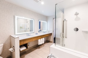 A modern bathroom with a glass-enclosed shower, a wooden vanity with a mirror, and a white sink. - Holiday Inn Express & Suites West Edmonton - Mall Area by IHG (Edmonton)