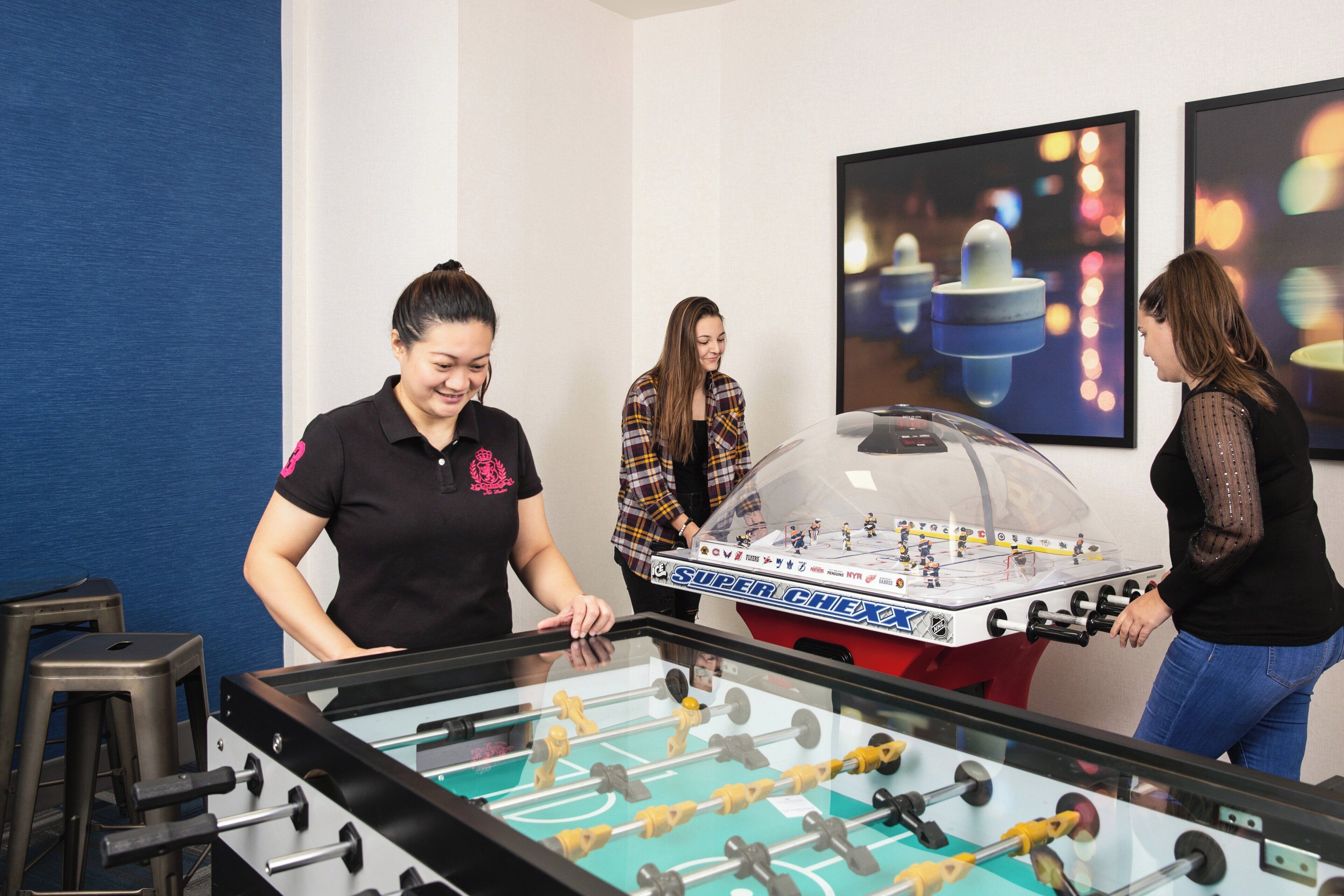 A room with a foosball table, a bar area, and a seating space.