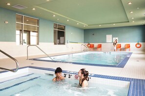 An indoor swimming pool with clear water, marked depth lines, and safety signs. - Holiday Inn Express & Suites West Edmonton - Mall Area by IHG (Edmonton)