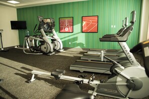 A gym with treadmills, stationary bikes, and a rowing machine.