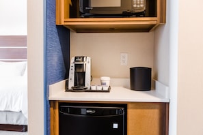 A compact kitchenette with a microwave, coffee maker, and a black mug on a white countertop. - Holiday Inn Express & Suites West Edmonton - Mall Area by IHG (Edmonton)