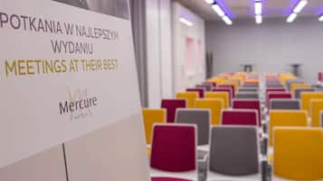 A conference room with rows of chairs and a sign indicating it is a meeting space.