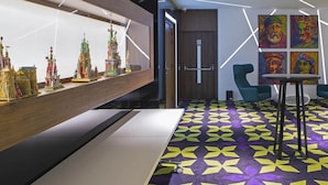 A modern interior with a model display, a patterned carpet, and artwork on the walls. - Mercure Krakow Stare Miasto (Old Town) (Kraków)