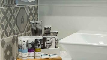 A bathroom with a white sink, a mirror, and toiletries on a wooden tray.