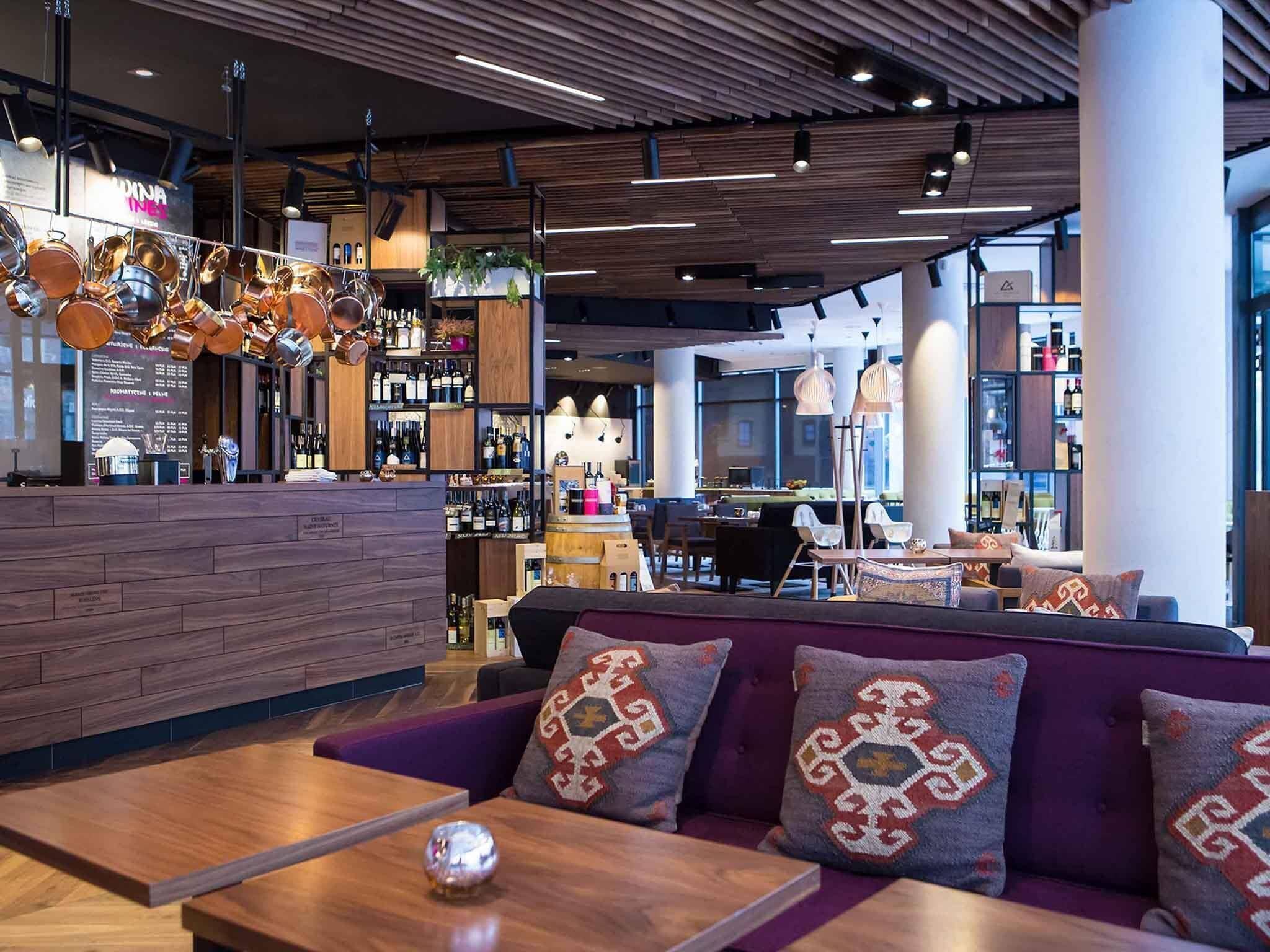Um interior moderno com área de bar, assentos e vista da cidade.
