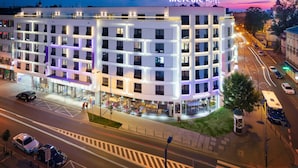 A modern hotel with a prominent sign, multiple floors, and a well-lit exterior. - Mercure Krakow Stare Miasto (Old Town) (Kraków)