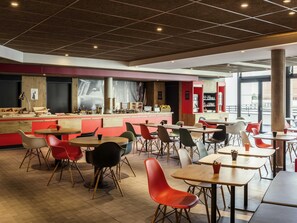 Un café moderne avec un comptoir, un espace salon et de grandes fenêtres.