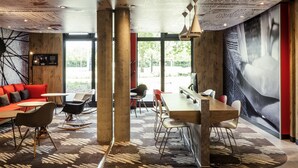 Ein modernes Interieur mit einem großen Tisch, Stühlen und einem roten Sofa.