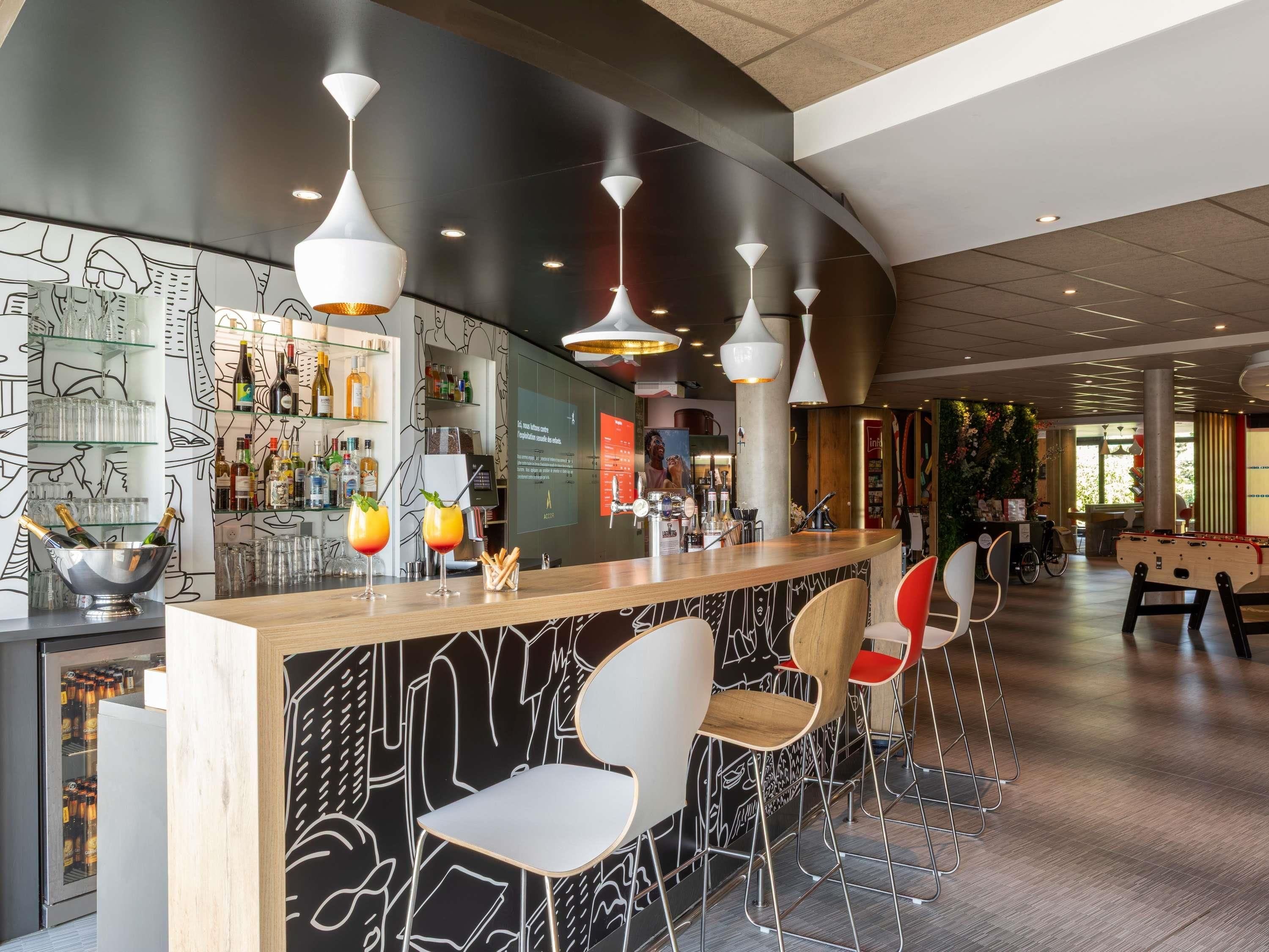 A bar area with a modern design, including a bar counter, seating, and ambient lighting.