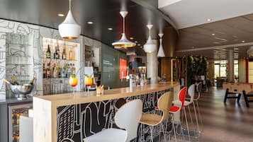 A bar area with a modern design, including a bar counter, seating, and ambient lighting.