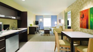 Una habitación de hotel moderna con cocina, una mesa de comedor y una sala de estar.