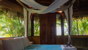 Un dormitorio con cama, almohadas y una mesita de noche.