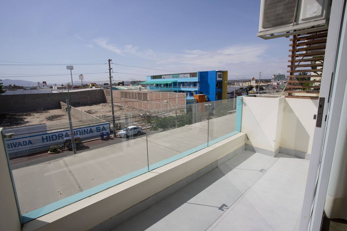 A balcony with a clear view of a road and buildings.