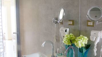 A modern bathroom with a large mirror, two sinks, and a hairdryer.