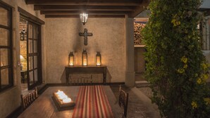 A cozy dining area with a wooden table, candles, and a cross on the wall. - Hotel Casa San Lázaro (Antigua Guatemala)