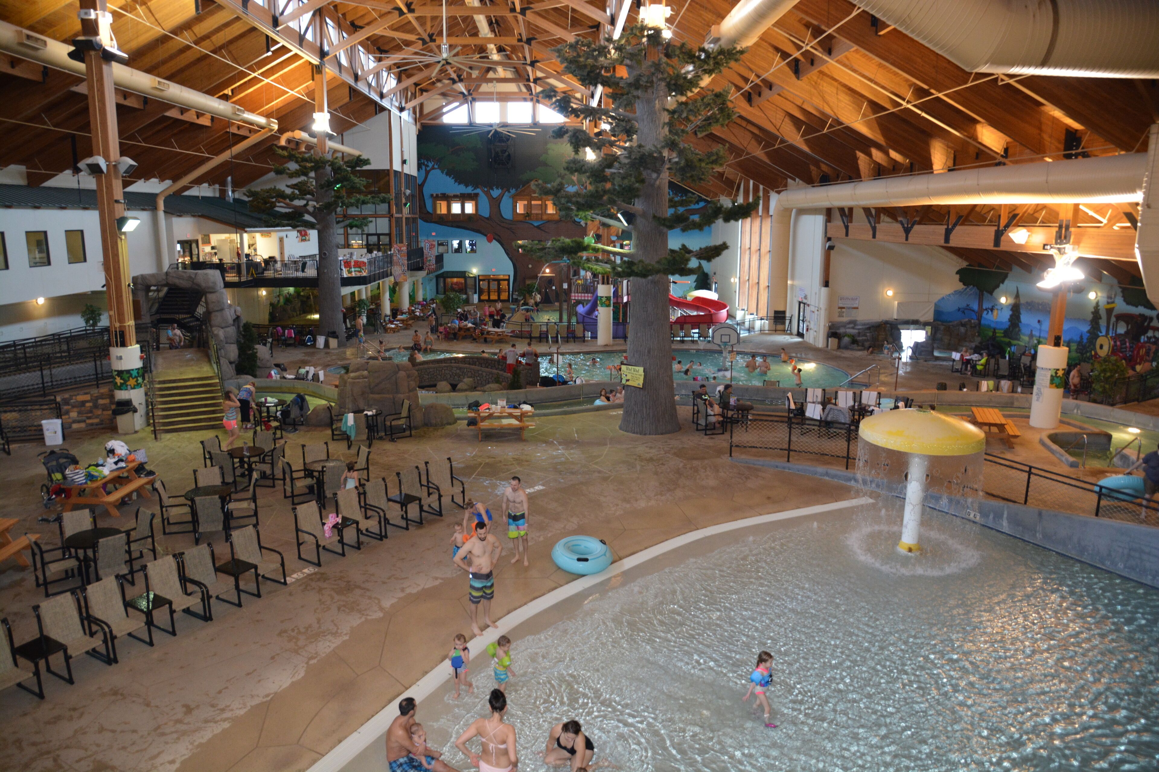 An indoor water park with a large pool, slides, and various play areas.