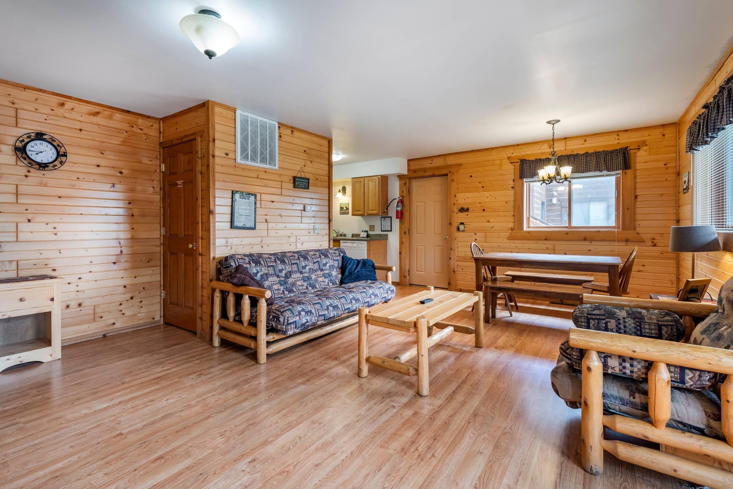 Un interior de madera con un sofá, una mesa de comedor y una zona de cocina.