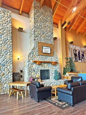 A stone fireplace with a sign reading "Ocean Spray Cranberry Grower," wooden furniture, and a Christmas tree.