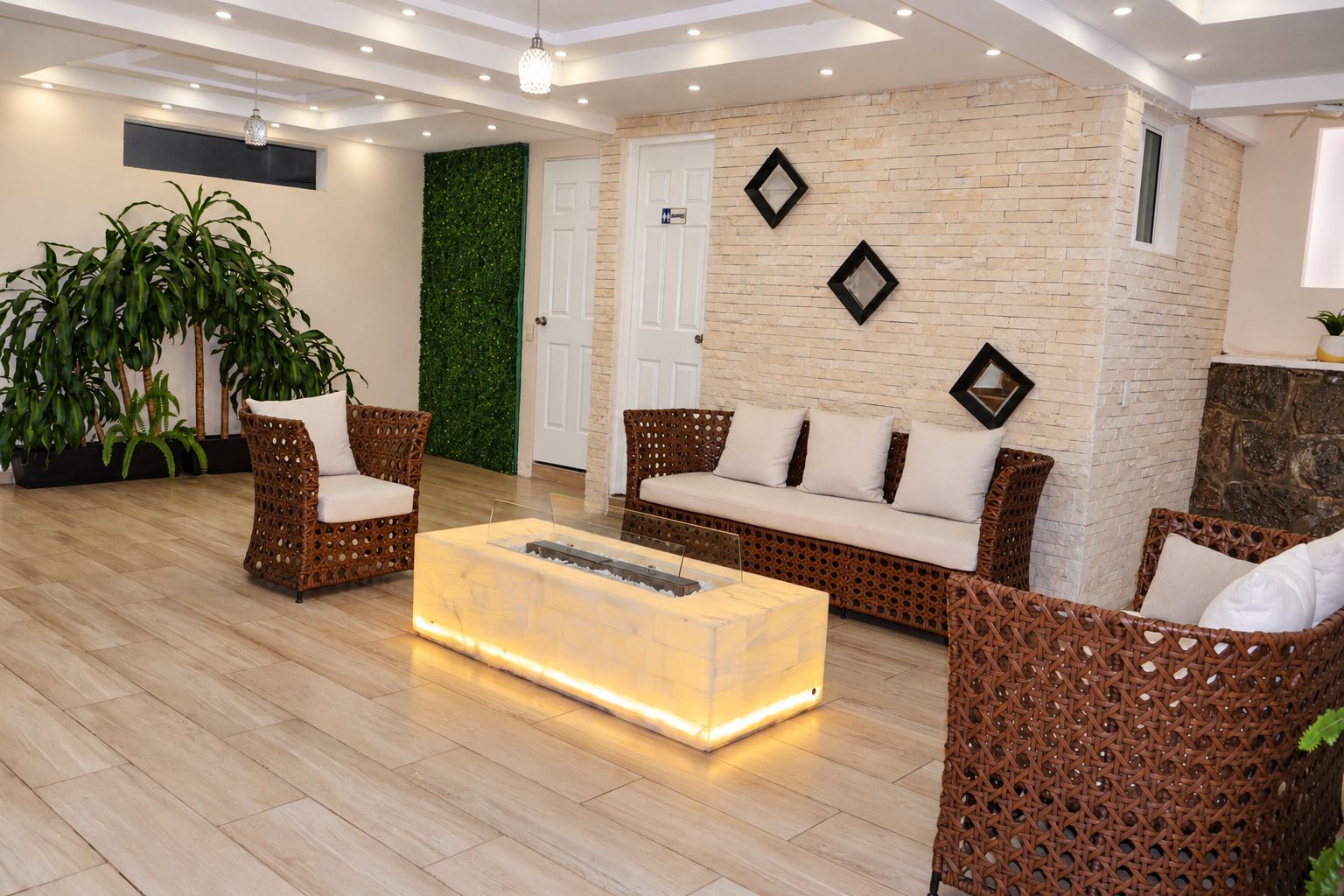 A modern living room with wicker furniture, a glass coffee table, and a brick accent wall.
