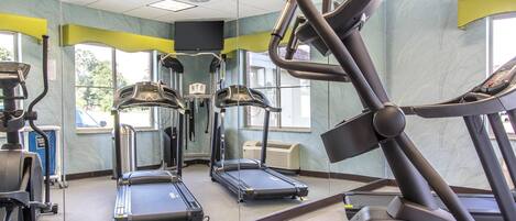 A gym with treadmills, elliptical machines, and a stationary bike.