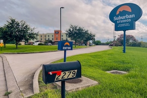 A suburban area with a street sign indicating an entry point to a hotel complex. - Suburban Studios Donaldsonville - Gonzales (Donaldsonville)