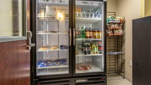 A self-serve beverage refrigerator stocked with various drinks and snacks. - Suburban Studios Donaldsonville - Gonzales (Donaldsonville)