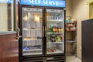 Un refrigerador de autoservicio repleto de bebidas y aperitivos.
