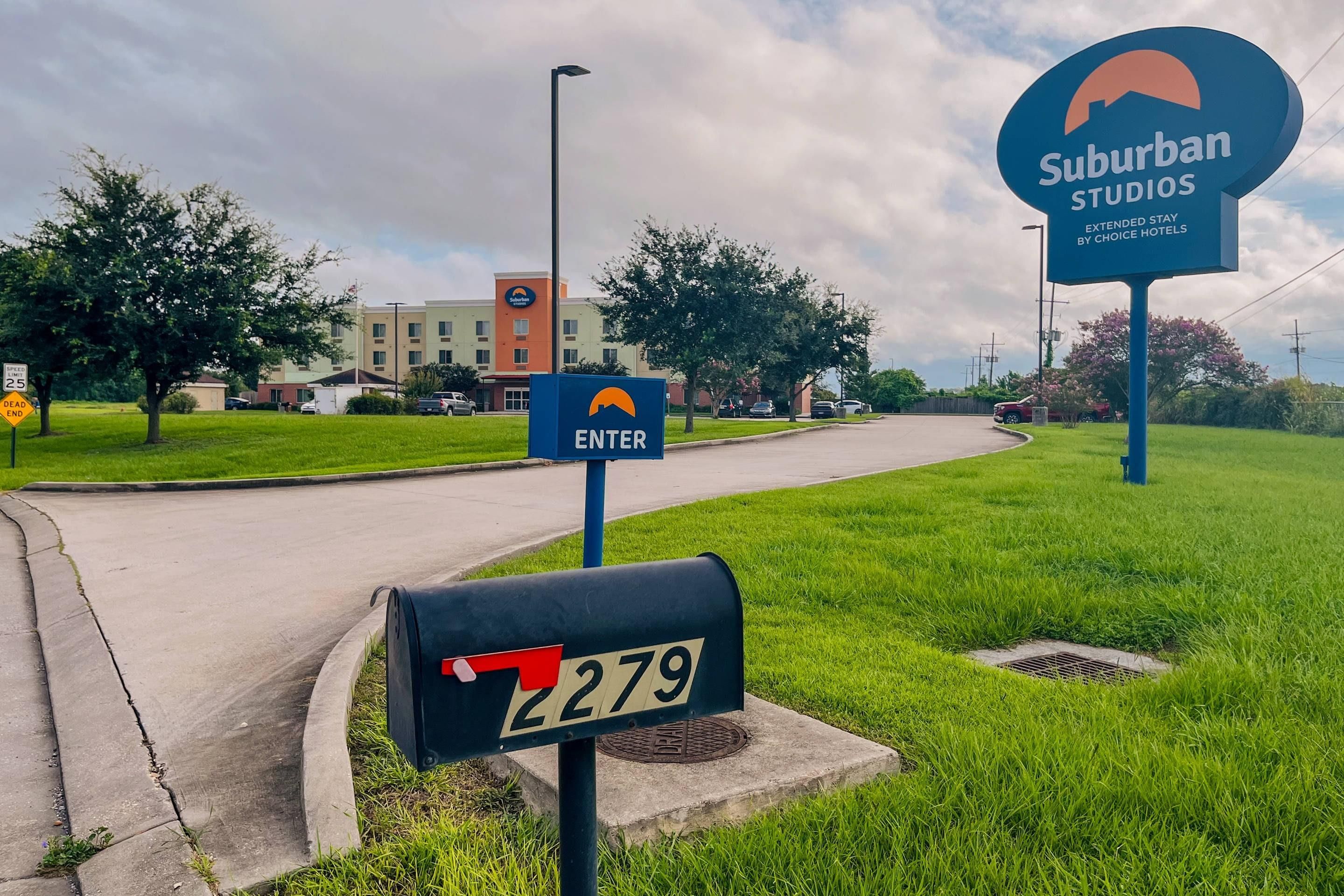 A suburban area with a street sign indicating an entry point to a hotel complex.