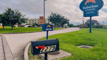 A suburban area with a street sign indicating an entry point to a hotel complex.