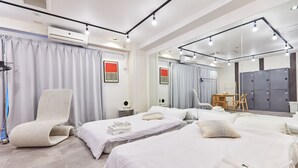 A hotel room with two beds, a large mirror, a chair, and a desk with a chair. - Tora Hotel Asakusa - Hostel (Tokyo)