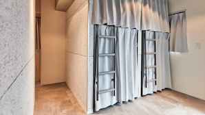A modern room with a built-in wardrobe, a ladder, and a window with curtains. - Tora Hotel Asakusa - Hostel (Tokyo)