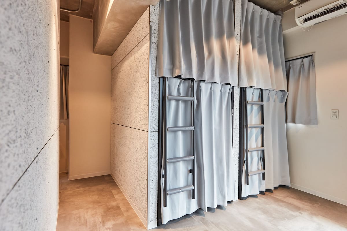 A modern room with a built-in wardrobe, a ladder, and a window with curtains.