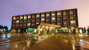 A modern hotel with a large, open entrance and multiple balconies. - Hansanan Hotel (Phitsanulok)