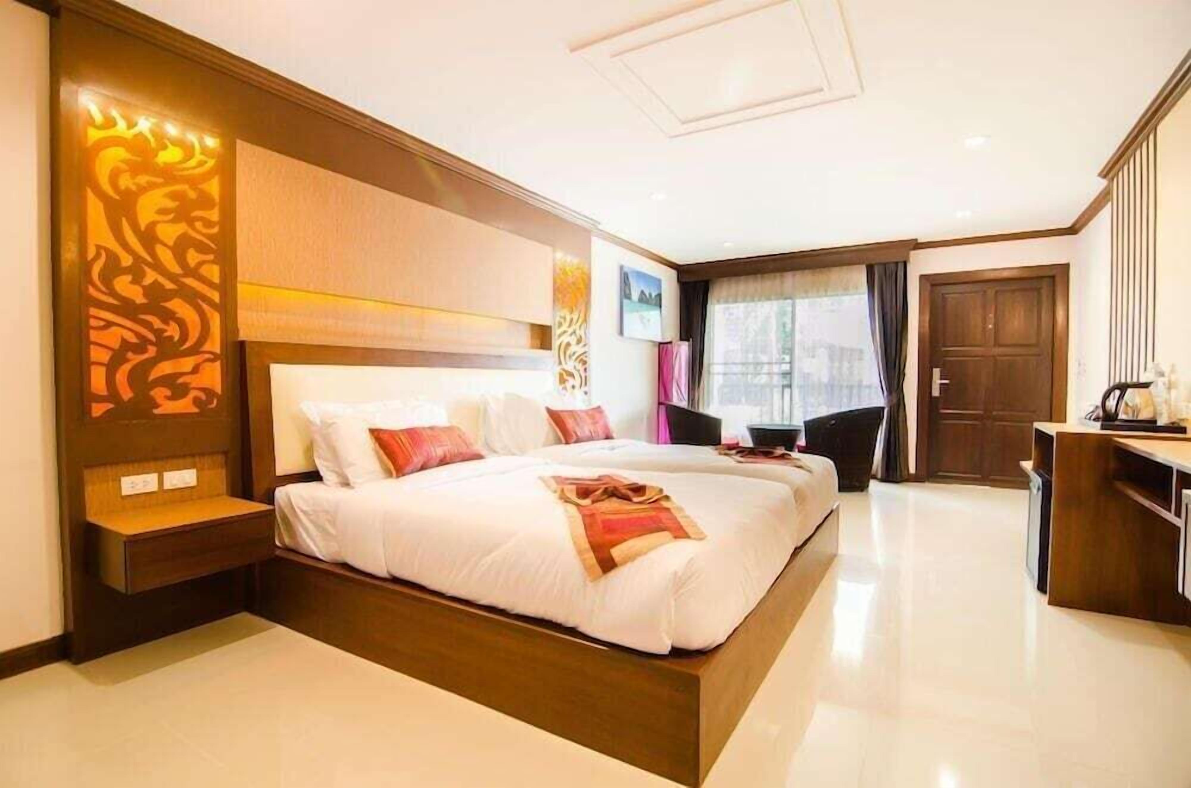 Una habitación de hotel moderna con una cama grande, mesitas de noche, un escritorio y un armario.