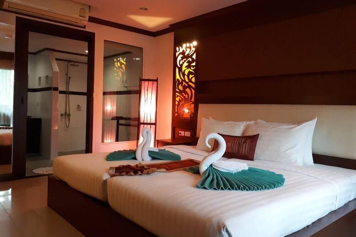 Ein Hotelzimmer mit einem großen Bett, einer Duschkabine und einer Wandverzierung.