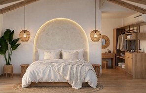 Une chambre avec un grand lit, des poutres apparentes, un miroir rond et une armoire en bois.
