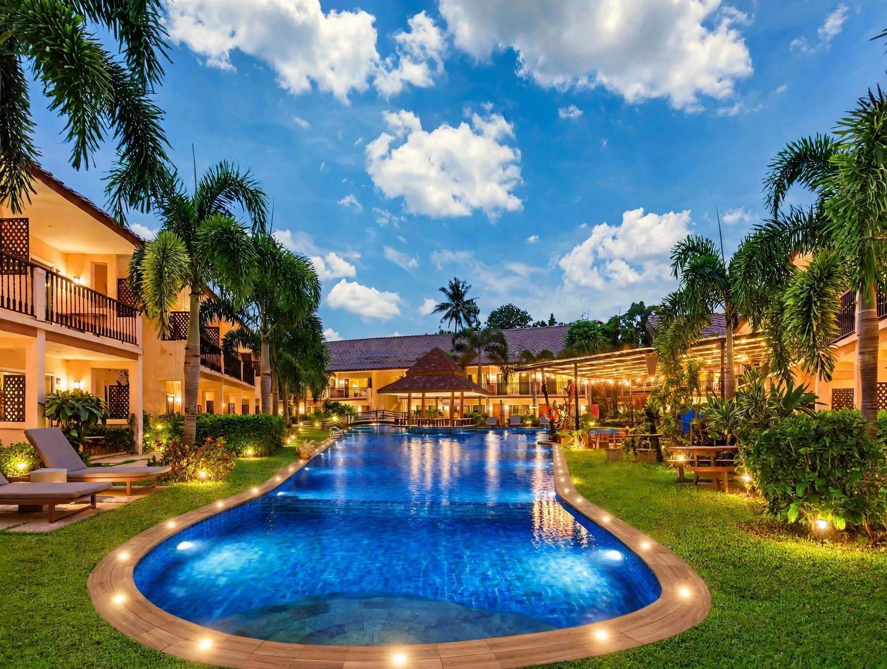 A hotel with a swimming pool, multiple balconies, and tropical landscaping.