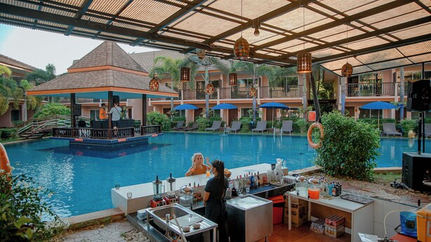 Ein Poolbereich mit Bar, Liegestühlen und einer überdachten Sitzgelegenheit.