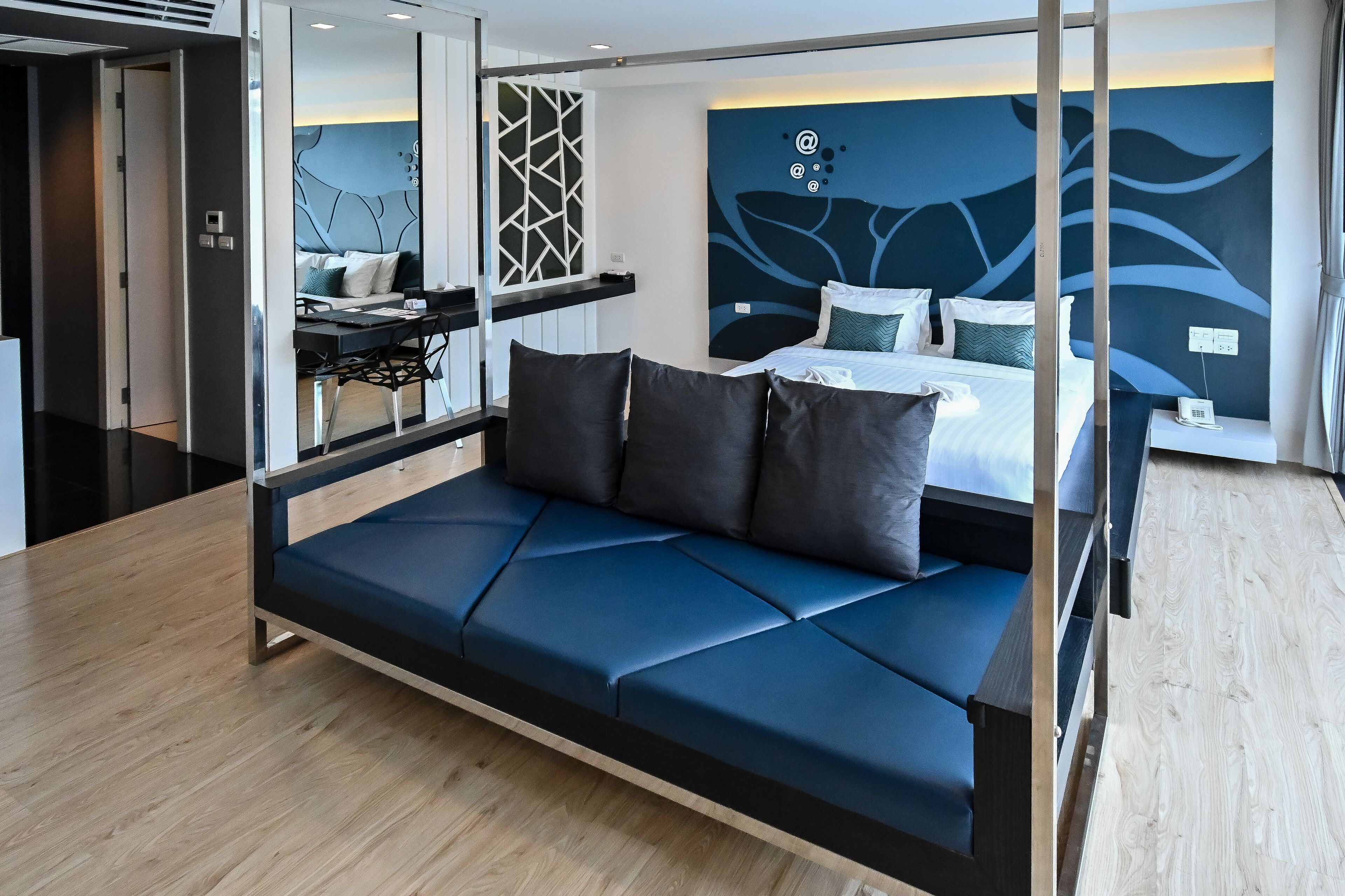 Una habitación de hotel moderna con una cama grande, un escritorio y un sofá.