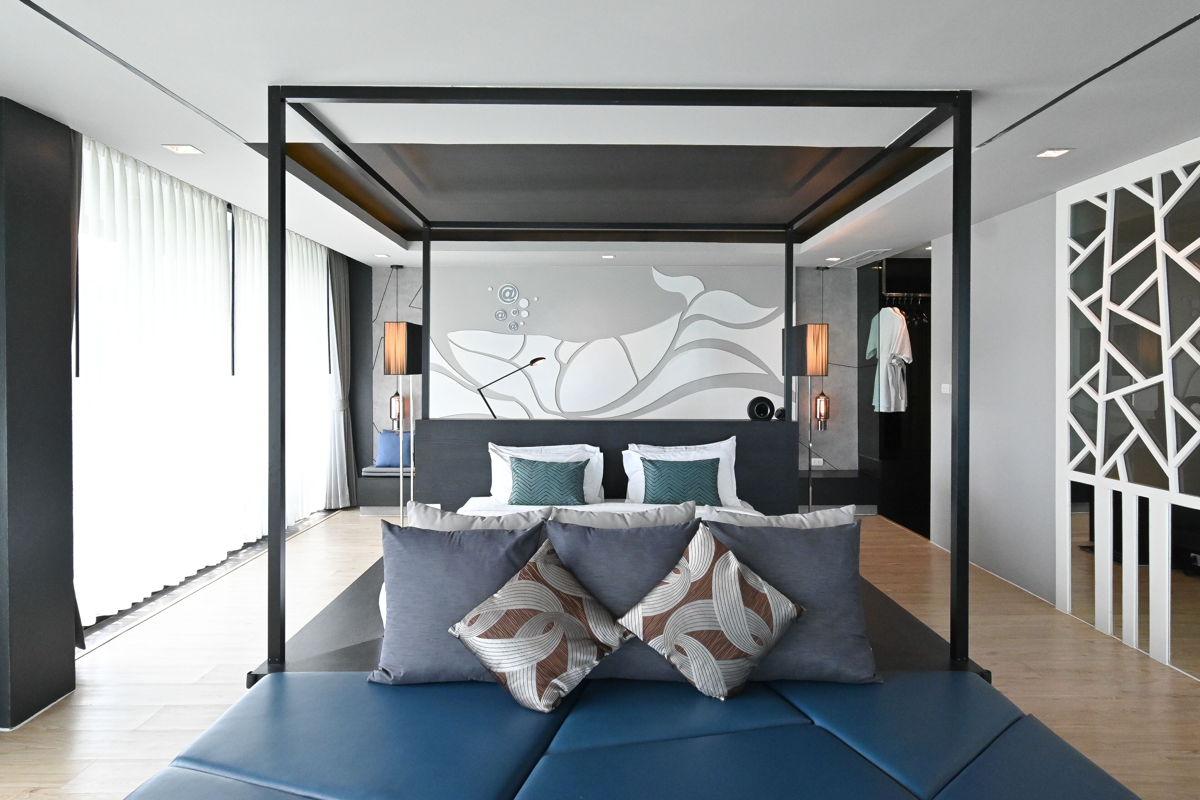 Une chambre à coucher moderne avec un lit, des oreillers et un mur décoratif.