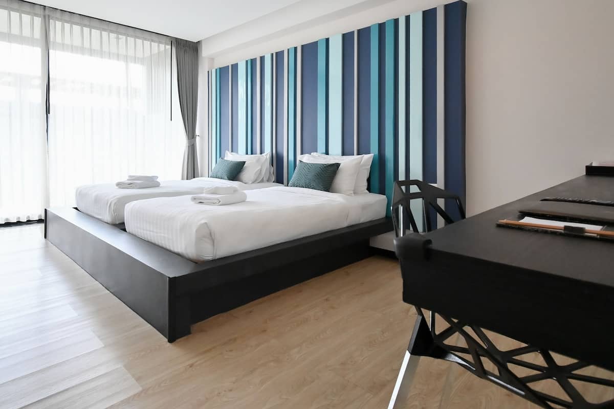 Ett modernt hotellrum med en stor säng, ett skrivbord och utsikt över staden.