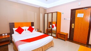 A hotel room with a large bed, a wardrobe, a bedside table, and a mirror. - Sea Shell Hotel (Manama)