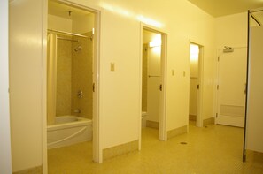 Een hotelbadkamer met bad, toilet en douche.