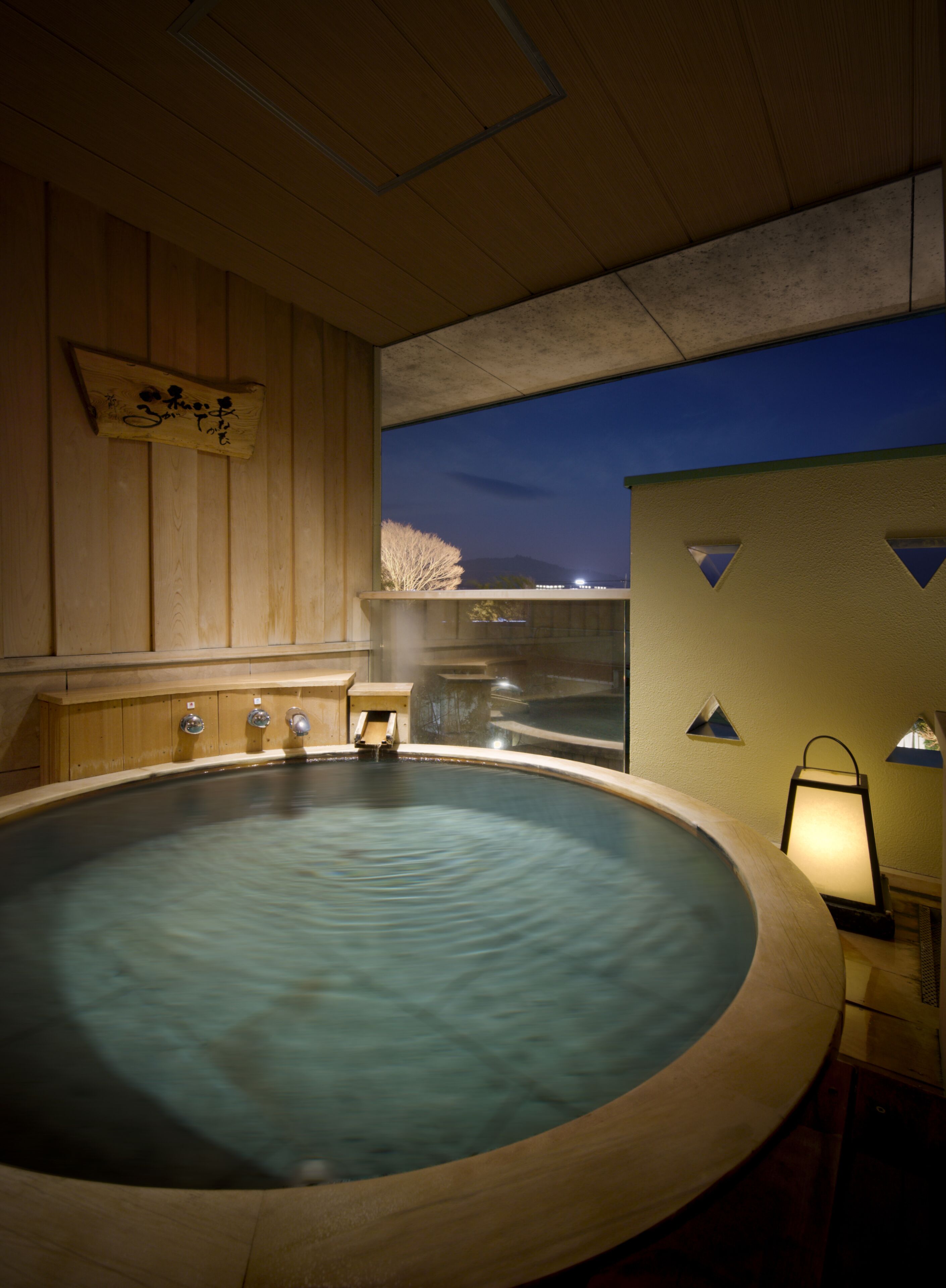 A hot tub with a wooden interior and a view of the night sky.