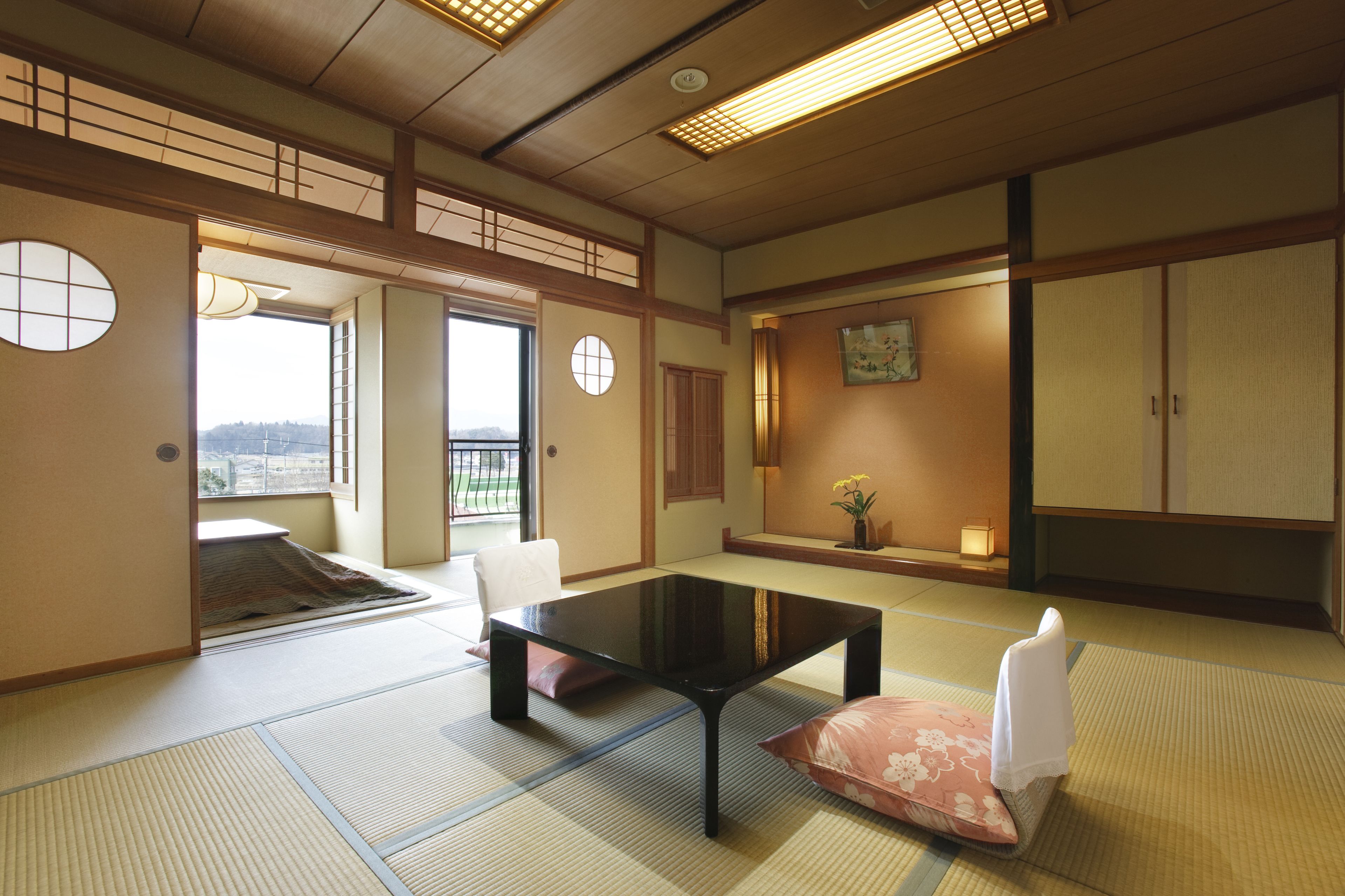 Una habitación japonesa tradicional con suelo de tatami, una mesa baja y puertas correderas.