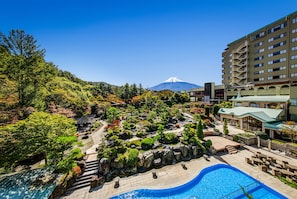 Un hôtel doté d’une piscine, de jardins luxuriants et offrant une vue sur une montagne.