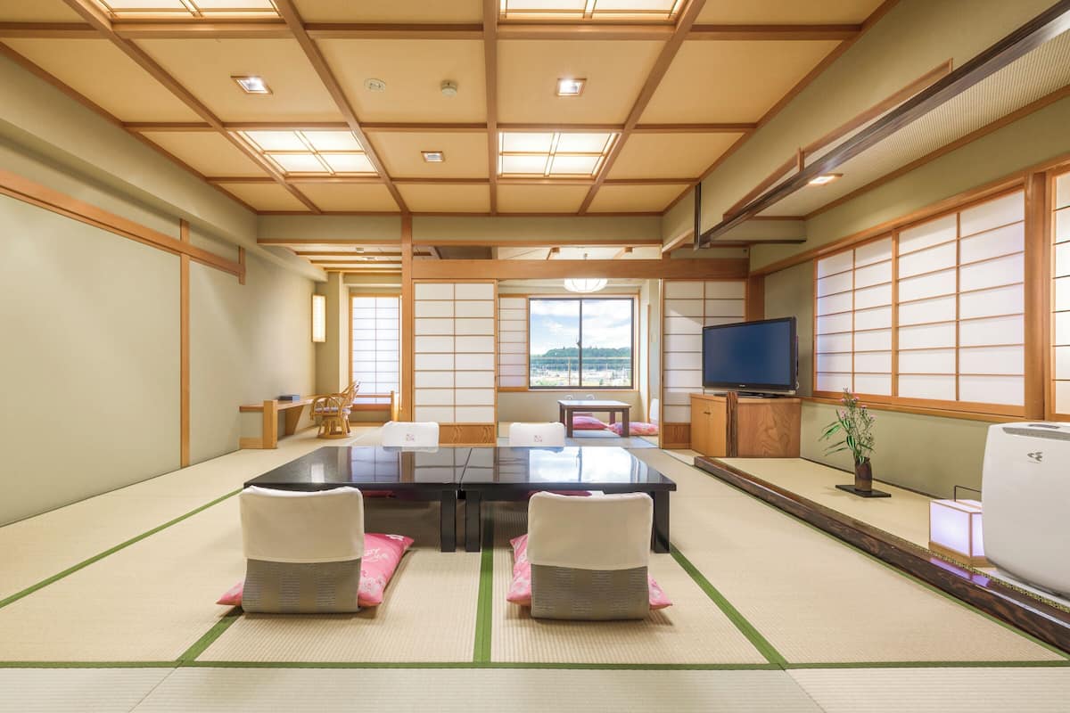 Ein traditioneller japanischer Raum mit Tatami-Böden, einem niedrigen Tisch und einem Fernseher.